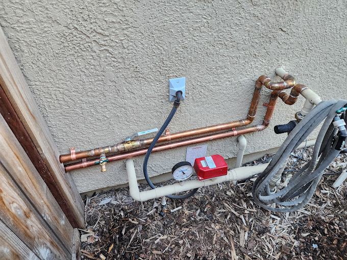Plumber working on copper pipes under a sink